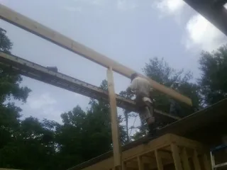 Carpenter setting a ridge beam over a new addition frame — Ice Dam Removal by Roofing Brothers in South Solon
