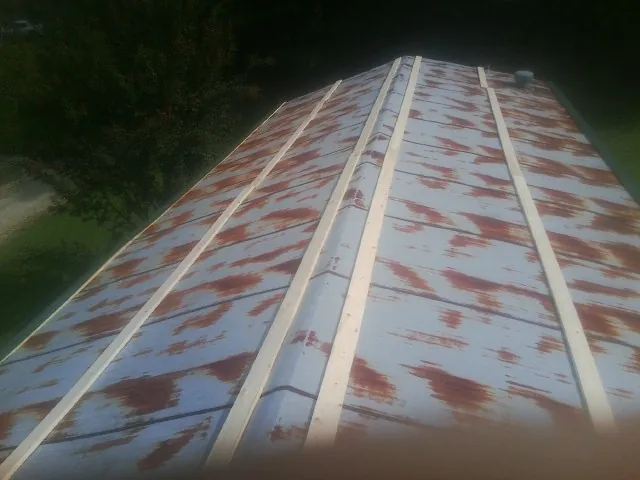 Rusted metal roof panels with new wood purlins before replacement — Storm Damage Roof Repair in South Solon by Roofing Brothers