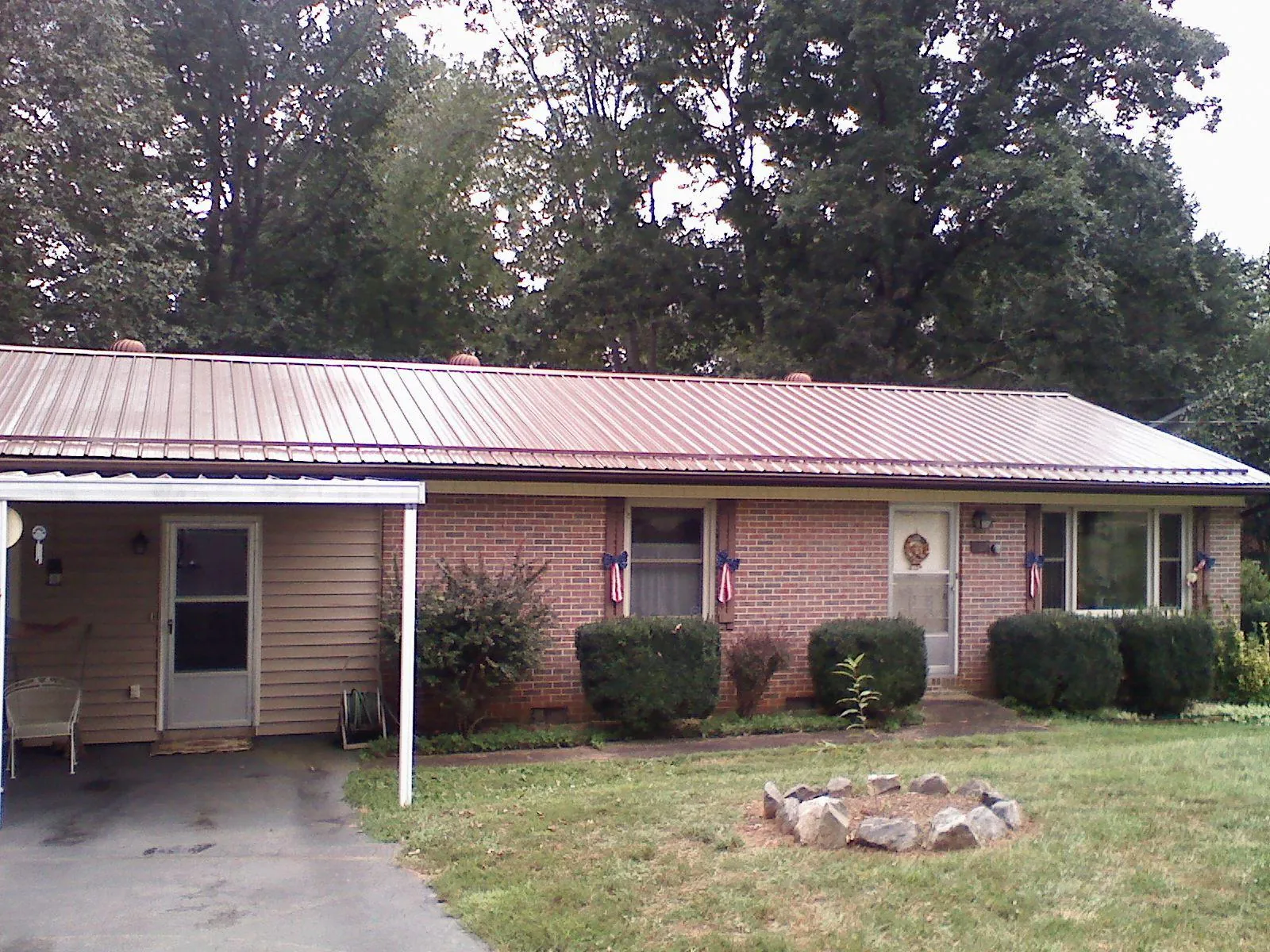 Bronze metal roof and carport on a brick ranch home in South Solon
